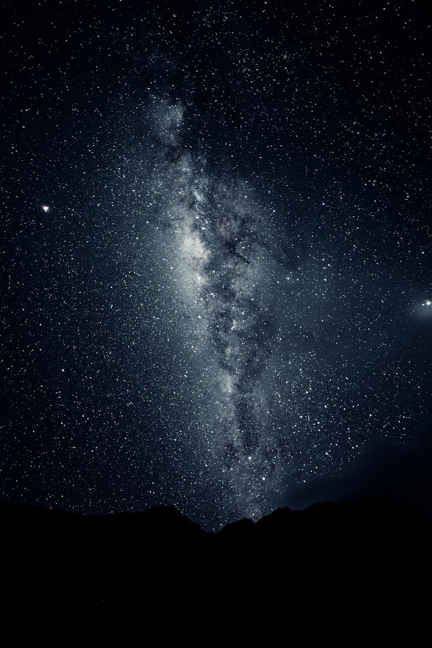 silhouette of mountain under starry night